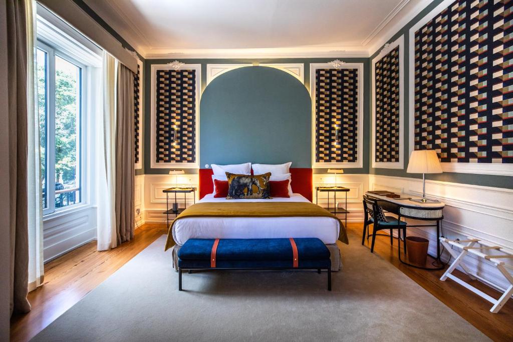 um quarto com uma cama, uma secretária e janelas em Sublime Lisboa em Lisboa