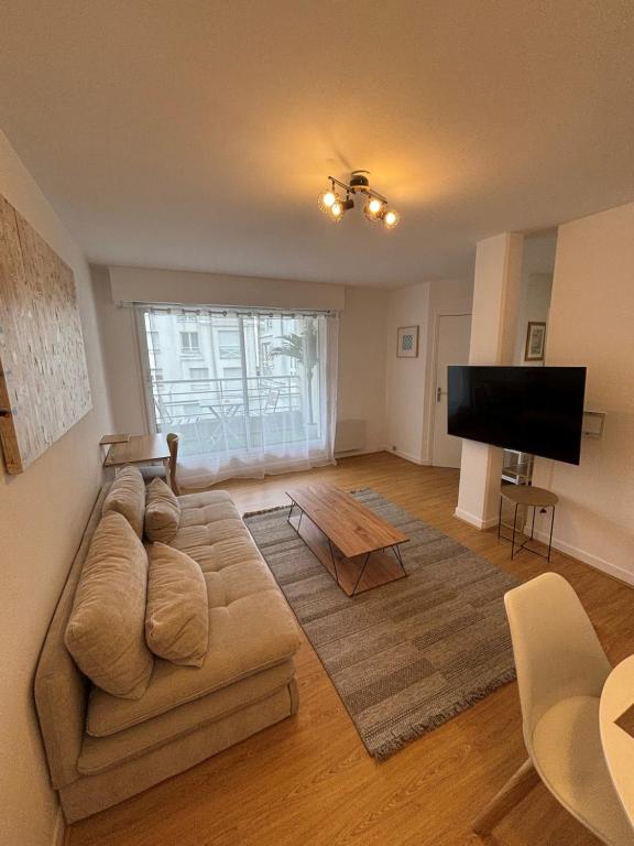 un salon avec un canapé et une télévision à écran plat dans l'établissement F2 calme et lumineux avec balcon au cœur du Vieux Lille, à Lille