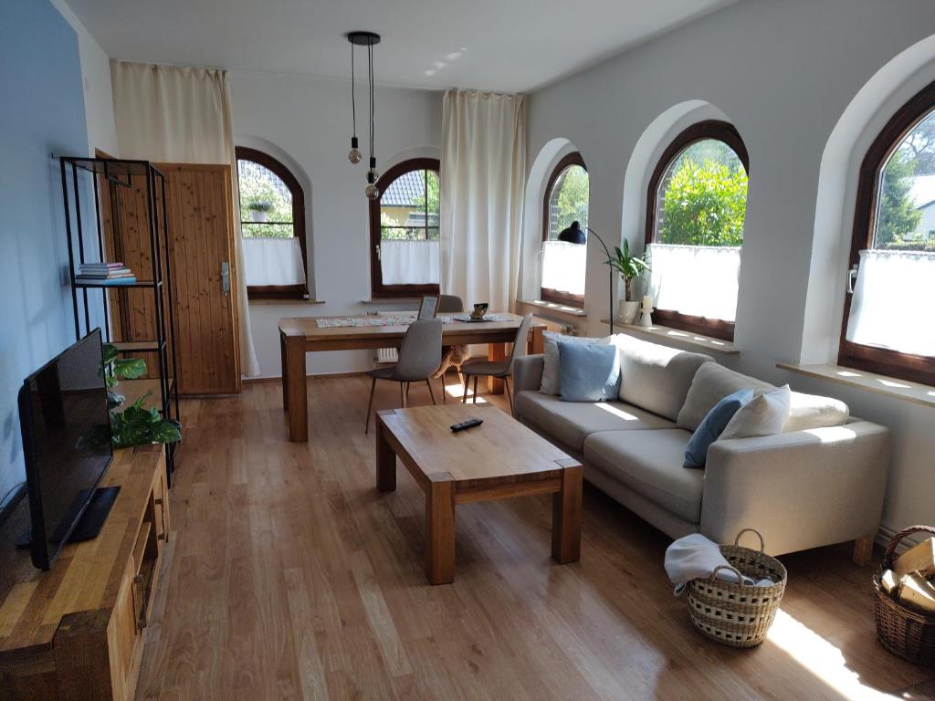 ein Wohnzimmer mit einem Sofa und einem Tisch in der Unterkunft Ferienwohnung AM SPREEUFER in Hangelsberg