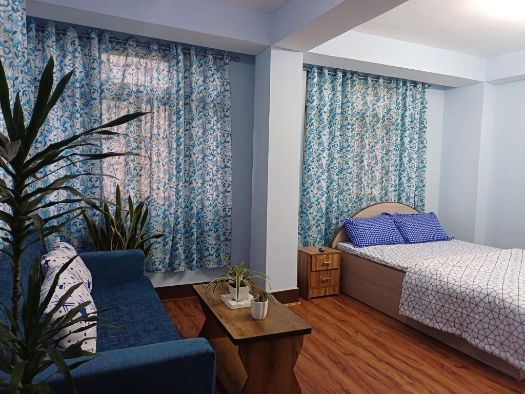 um quarto com uma cama, um sofá e uma mesa em Bluebird'snest em Gangtok