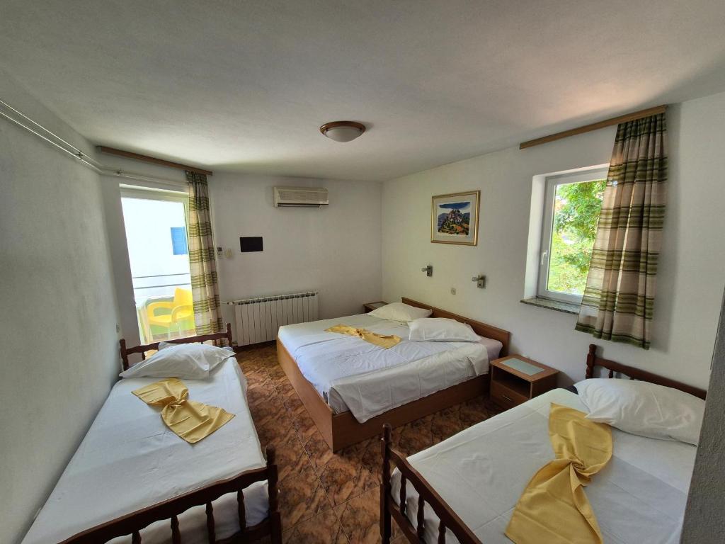 um quarto com duas camas e duas janelas em Hotel Biergarten Medulin em Medulin
