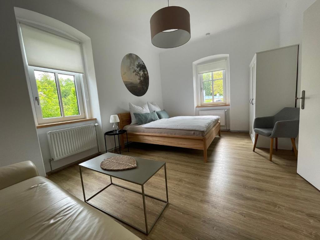 バート・アウスゼーにあるDie alte Salzvillaのベッドルーム1室(ベッド1台、ソファ、テーブル付)