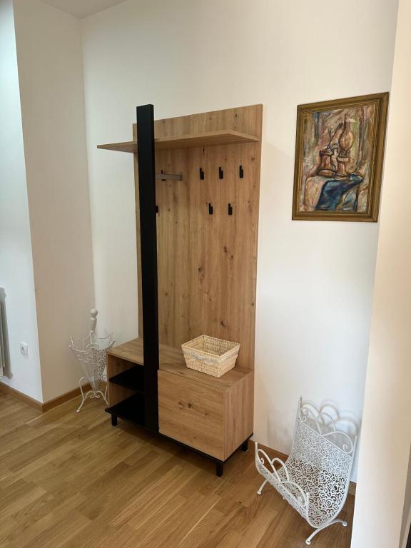 a wooden cabinet in a room with a picture on the wall at Stan na Dan Vrbas Zeljko in Vrbas