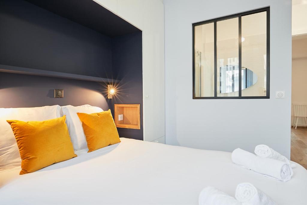 - une chambre avec un grand lit blanc et des oreillers jaunes dans l'établissement Florida emplacement parking, à Annecy