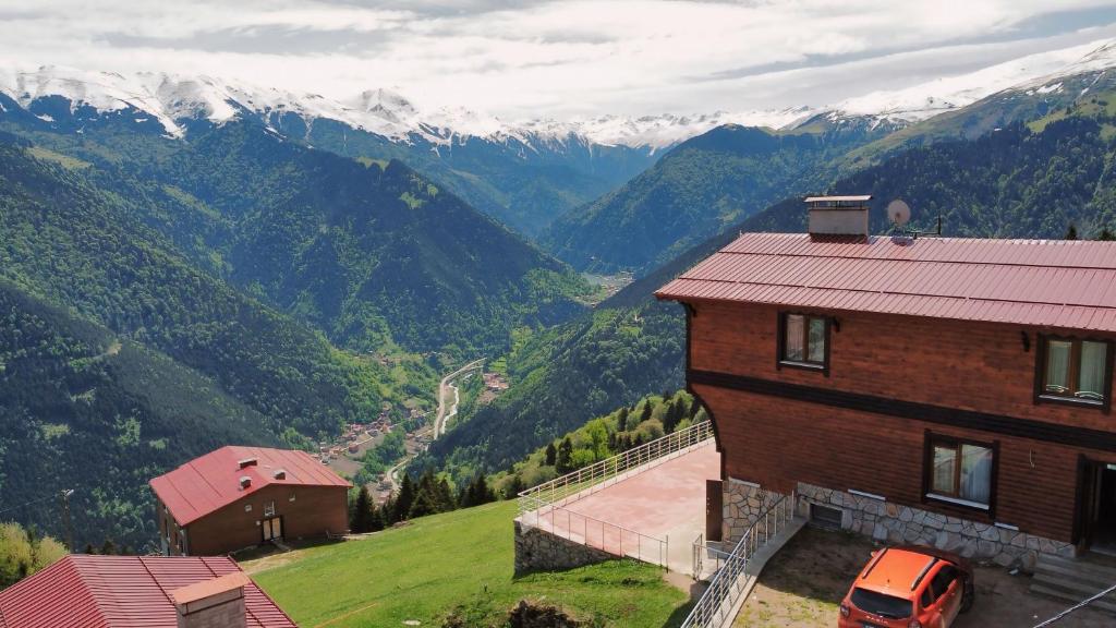 a house on a hill with a view of mountains at Kalispera Apart Otel in Uzungöl