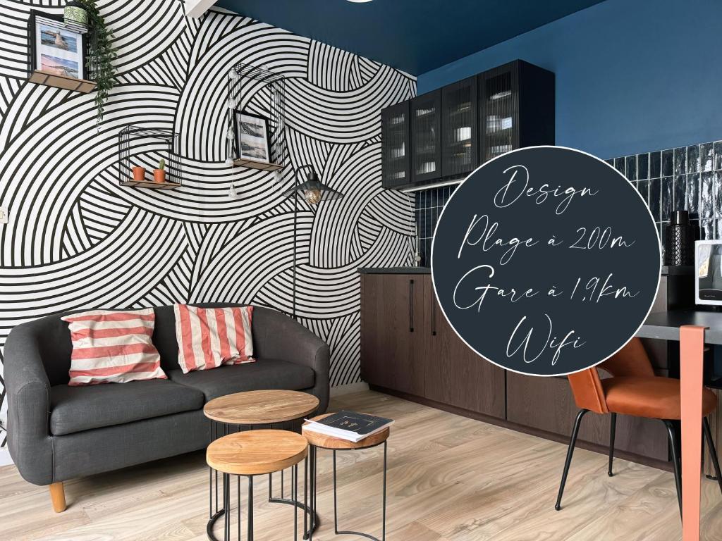 ein Wohnzimmer mit einem Sofa und einer Wand in der Unterkunft WANDERLUST - Studio confort à 100m plage Solidor in Saint-Malo