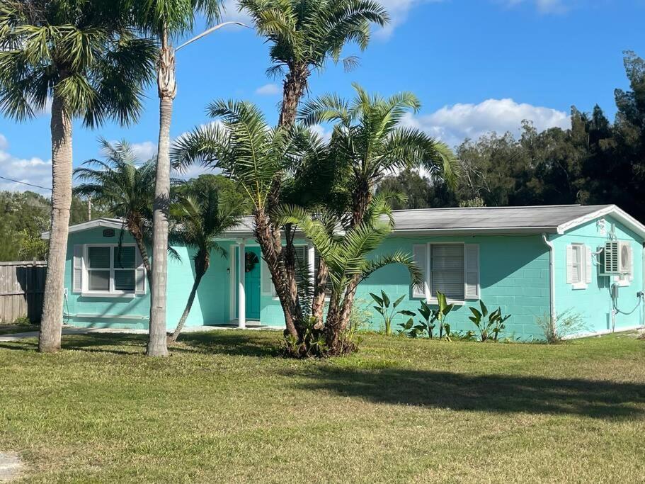 uma casa azul com palmeiras em frente em Northern Point of Treasure Island, New Port Richey em New Port Richey