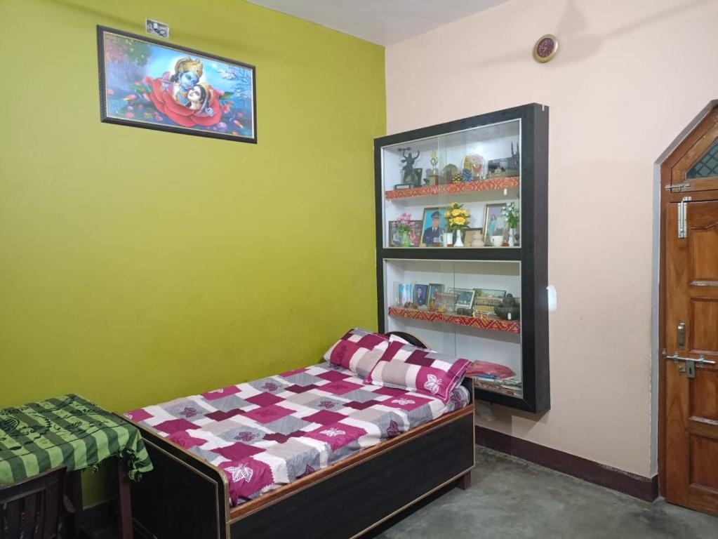 a room with a bed in front of a refrigerator at Sangeeta's in Ayodhya
