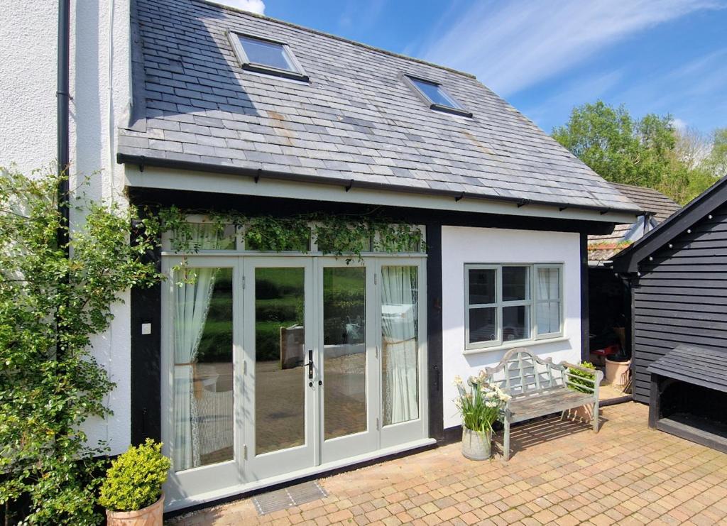 une extension vers une maison avec portes coulissantes en verre dans l'établissement Keep Cottage - East Devon, à Southleigh