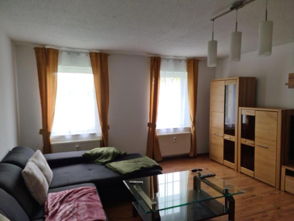 a living room with a couch and a glass table at Ferienwohnung II, Schloßstraße Kottmarsdorf in Kottmarsdorf