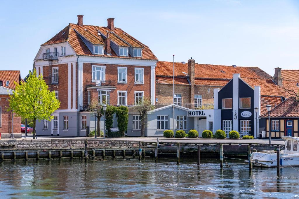 SkælskørにあるHotel Postgaardenの水の横に桟橋がある建物
