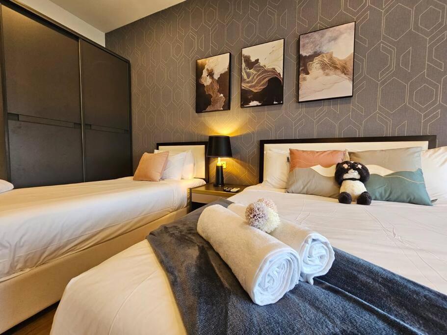 una camera con due letti e un orsacchiotto sul letto di Stylish Ceylonz Suite near Bukit Bintang 4pax a Kuala Lumpur