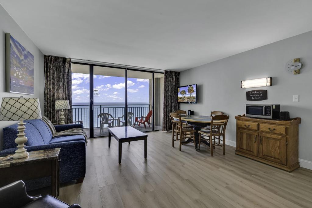 een woonkamer met een bank en een tafel bij Scenic Views from the balcony at Ocean Forest Plaza Condos in Myrtle Beach