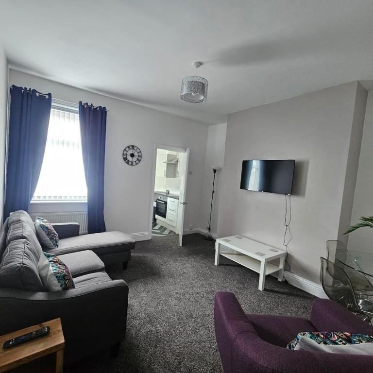 een woonkamer met 2 banken en een flatscreen-tv bij Lyndhurst Place, Sunderland in Sunderland