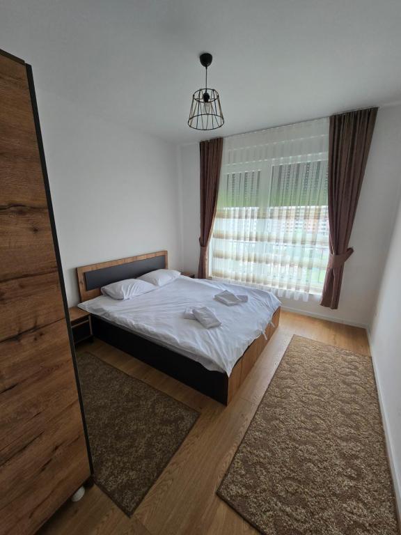 - une chambre avec un lit et une grande fenêtre dans l'établissement Dardania 2 Kastrati, à Prizren