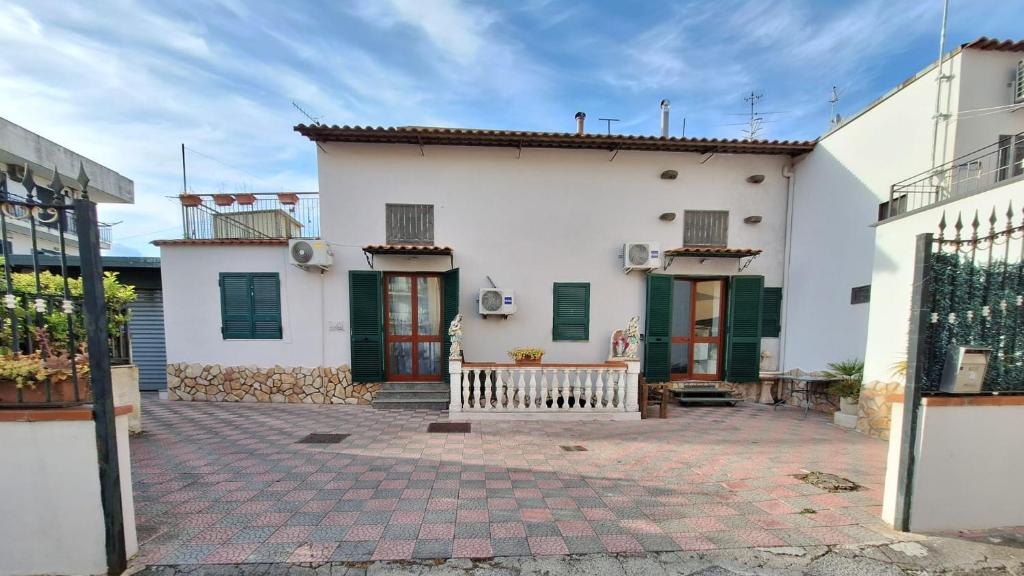 une maison blanche avec des volets verts et une cour dans l'établissement My Home, à Pompéi