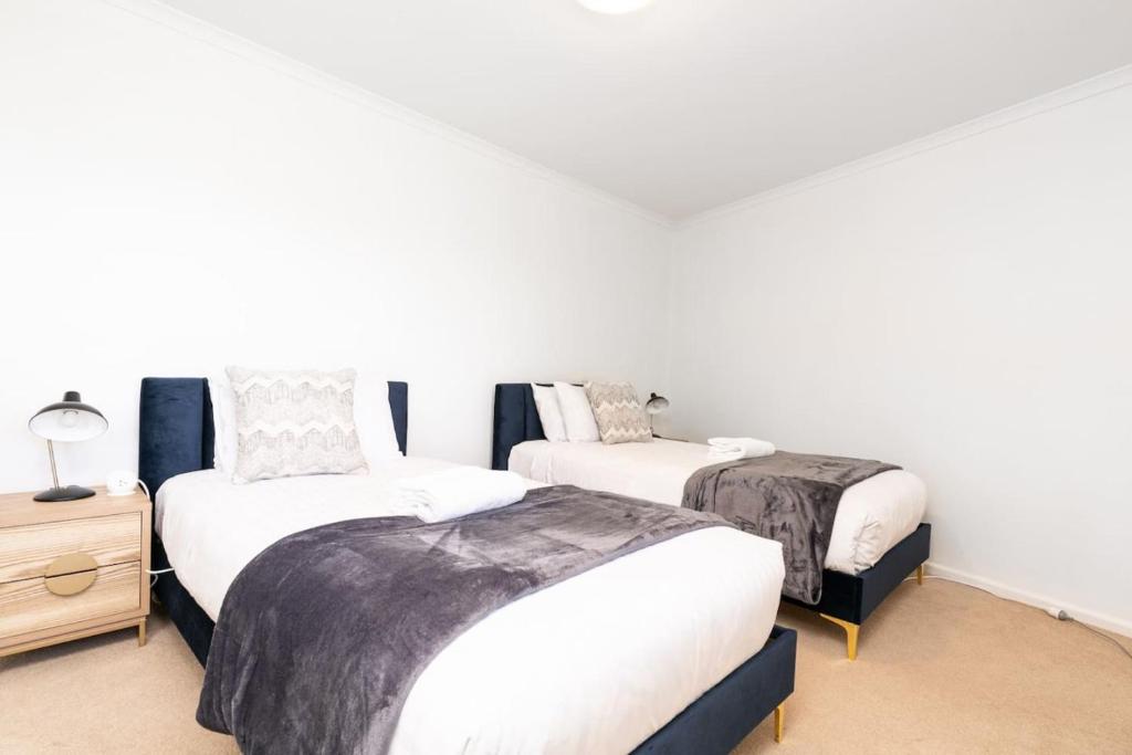 金斯顿2BR 2BA Apt with Dedicated Workspace and Free parking - Hosted by CanStay的一间白墙房间里有两张床