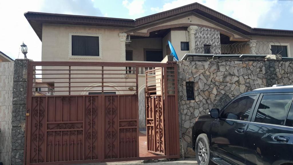 a house with a gate and a car parked in front at Magodo Treat in Lagos