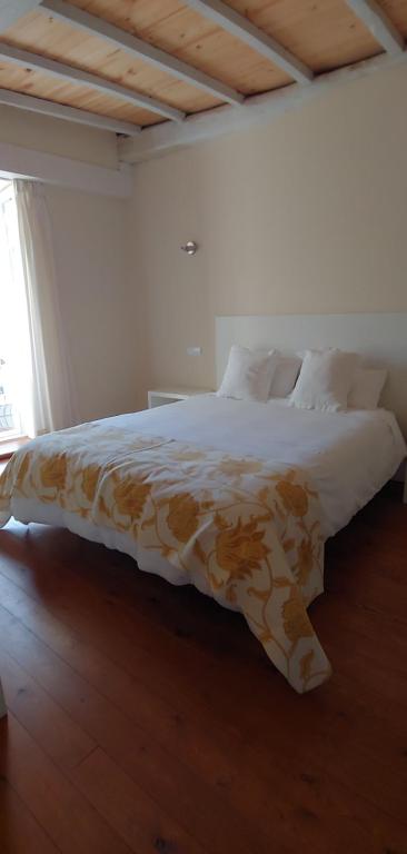 1 dormitorio con 1 cama con manta marrón y blanca en Hostal Camponaraya, en Camponaraya
