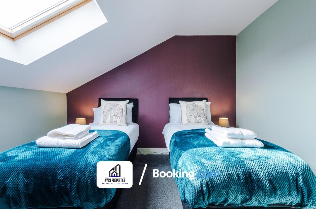 Pokój z 2 łóżkami z niebieską i białą pościelą w obiekcie 4 Bedroom House Free Parking By NYOS PROPERTIES Short Lets & Serviced Accommodation Manchester w Manchesterze