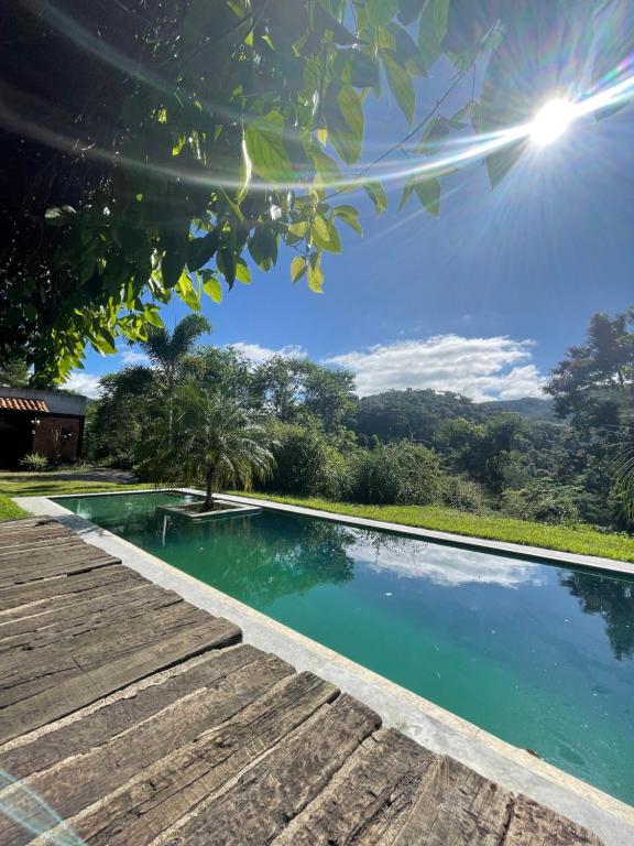 een zwembad naast een houten loopbrug bij Cabanas Arcádia in Engenheiro Paulo de Frontin