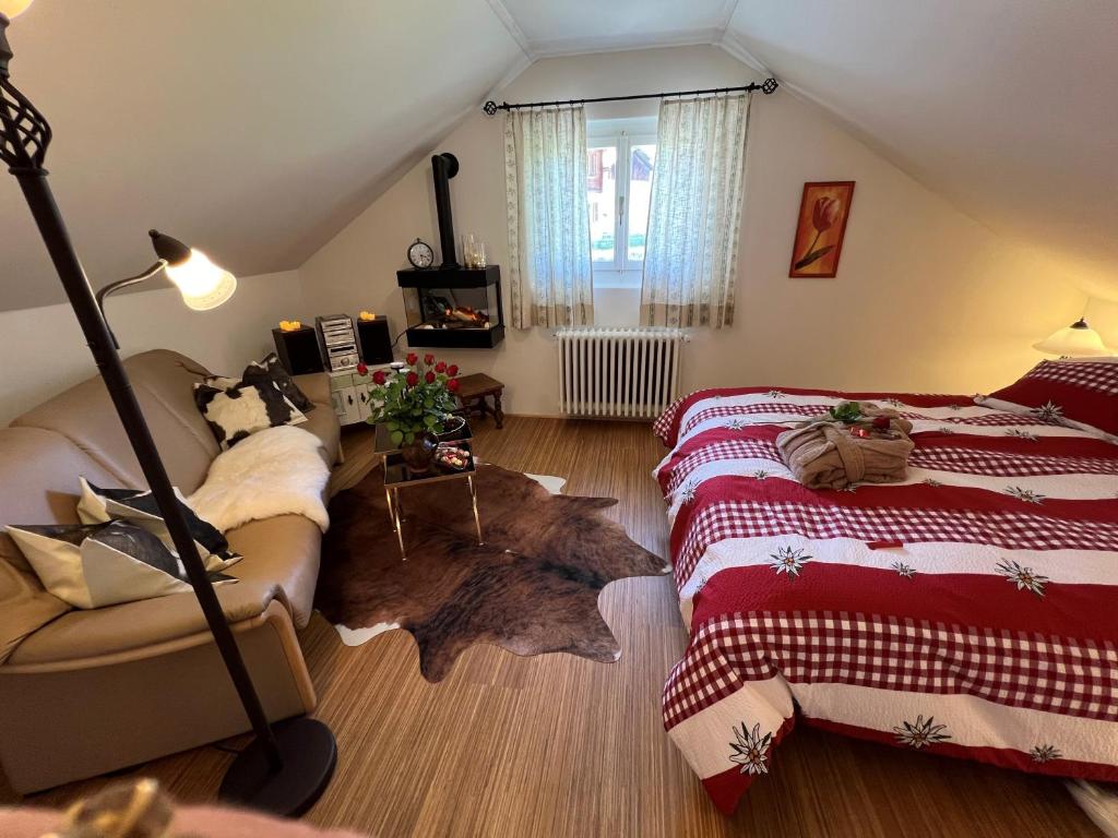 een slaapkamer op zolder met 2 bedden en een houten vloer bij Engel Ingold Lodge Chalet "Bärgblümli" in Habkern