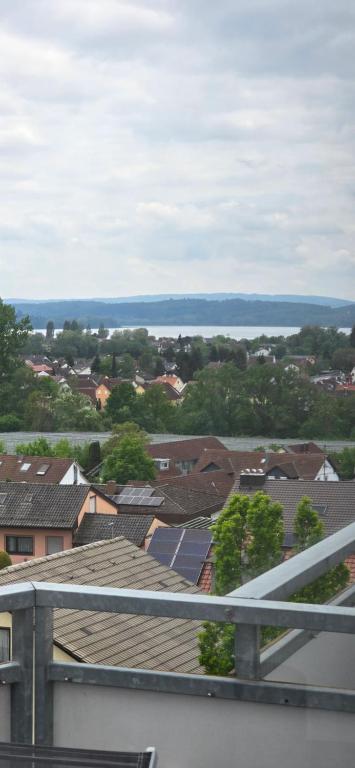 a view of roofs of houses and the ocean at Penthouse Schloßbühl in Uhldingen-Mühlhofen