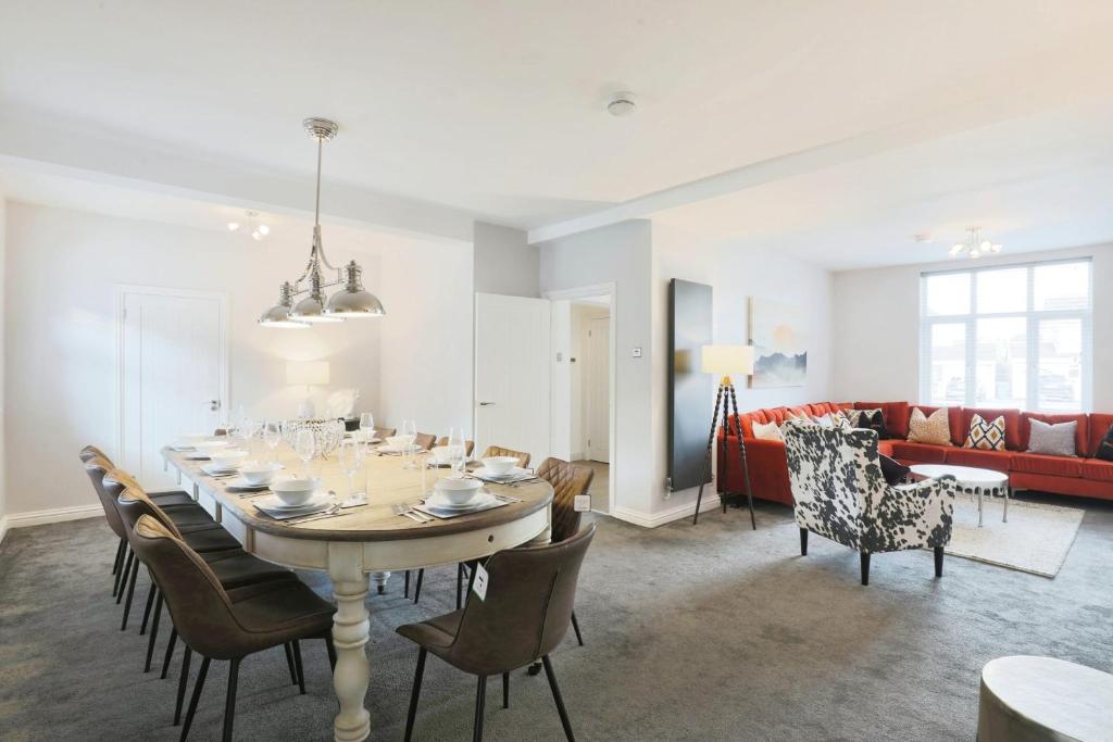 a dining room and living room with a table and chairs at Luxurious 7-Bedroom Home in Solihull, close to NEC & BHX in Solihull