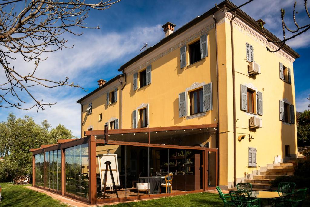 a large yellow building with a glass extension at Locanda De Banchieri in Fosdinovo