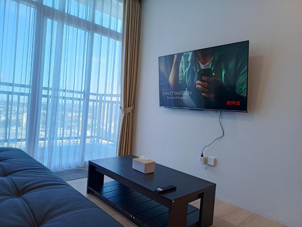a living room with a couch and a flat screen tv at Family Holiday Fun APT Netflix by MESA in Nagoya