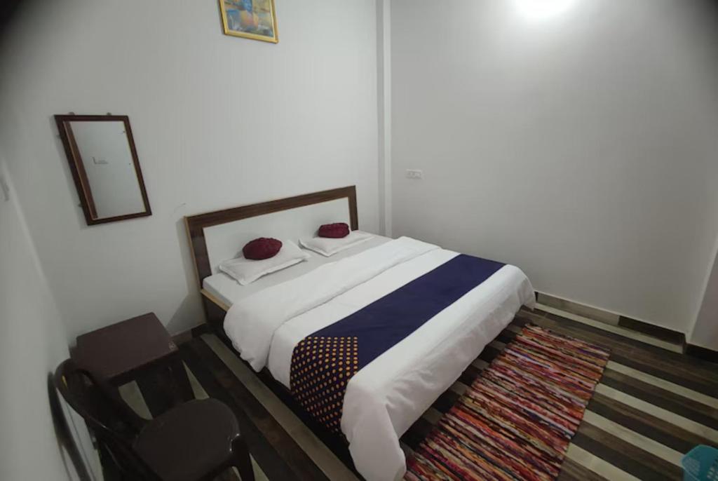 1 dormitorio con 1 cama y 1 silla en Goroomgo Hotel Kashi Nest Varanasi - A Peacefull Stay & Parking Facilities en Varanasi