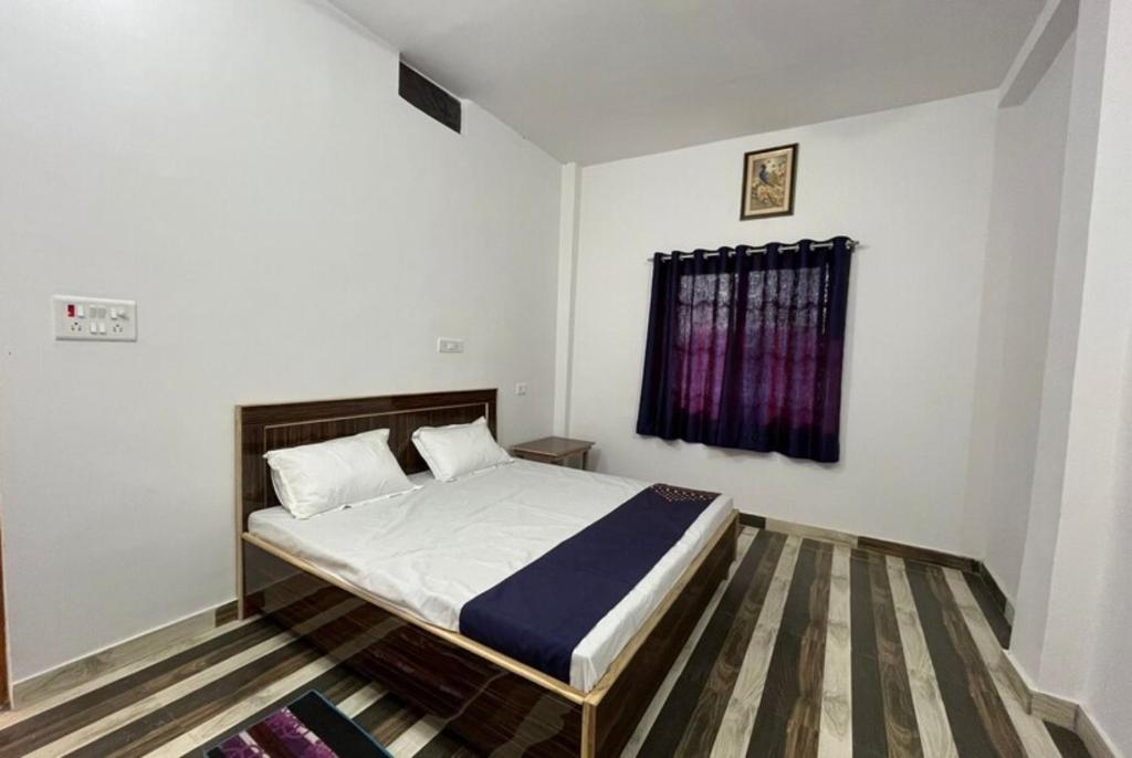 Goroomgo Hotel Kashi Nest Varanasi - A Peacefull Stay & Parking Facilities في فاراناسي: غرفة نوم بسرير ونافذة