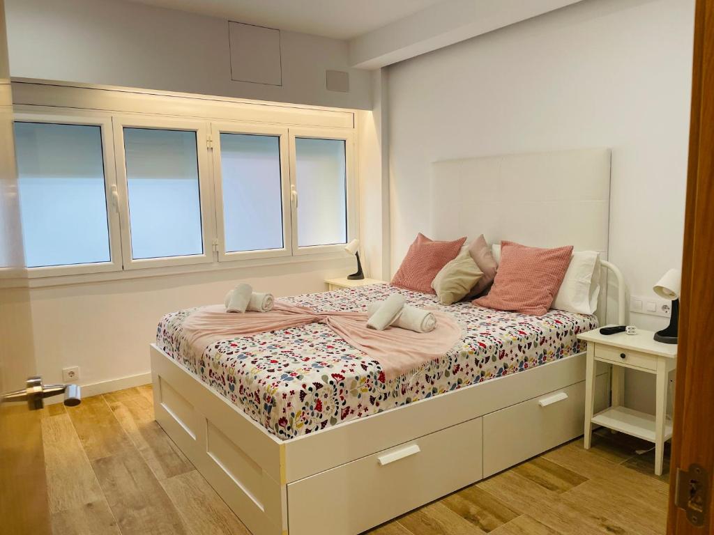 a bedroom with a bed with pink pillows on it at Sweet Room Barcelona in Hospitalet de Llobregat