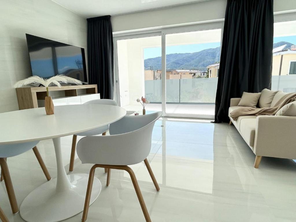 Smart Luxury Suites & Apartments في أروسييْ: غرفة معيشة مع طاولة وكراسي بيضاء