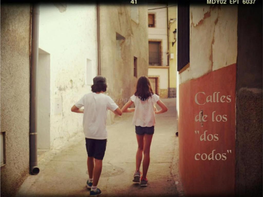 dos personas caminando por una calle tomados de la mano en Casa Rural Zaragoza, en Almonacid de la Sierra