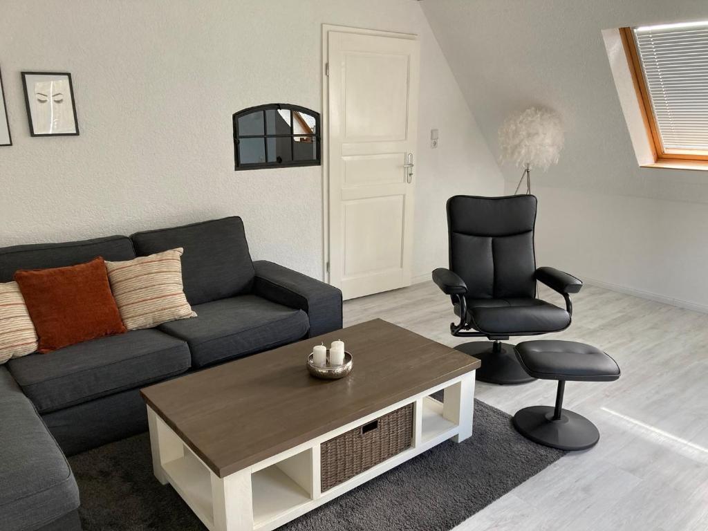een woonkamer met een bank en een stoel bij Lübecknah ! in Herrnburg