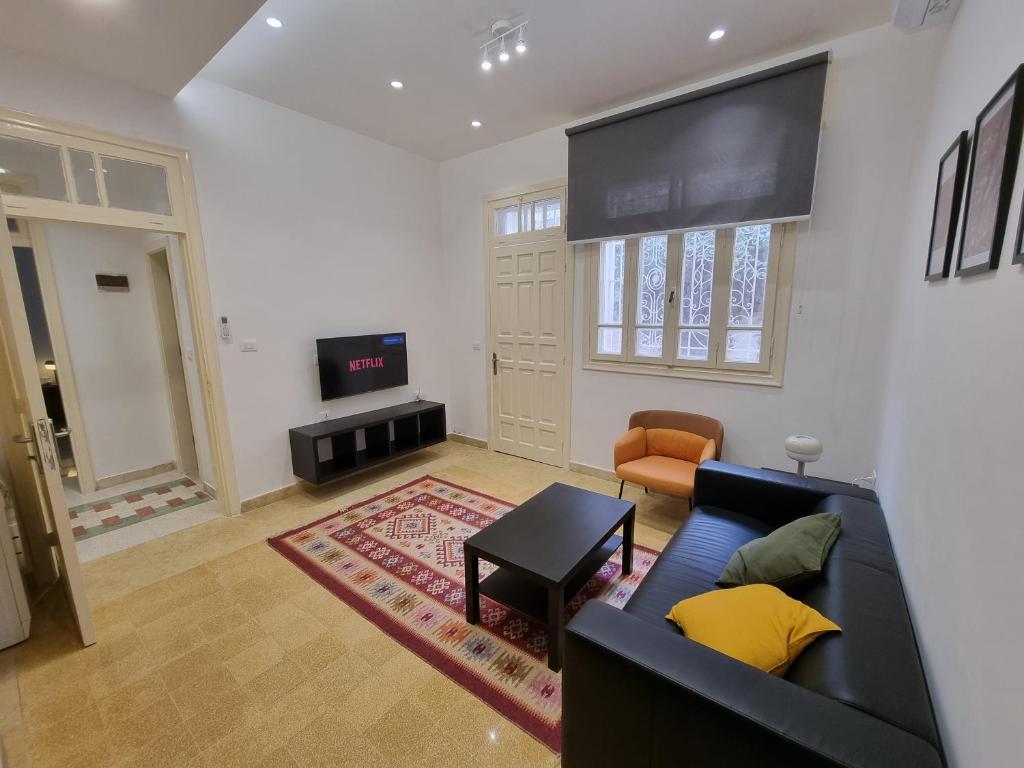 a living room with a couch and a flat screen tv at Downtown Living Boutique Apartments in Amman
