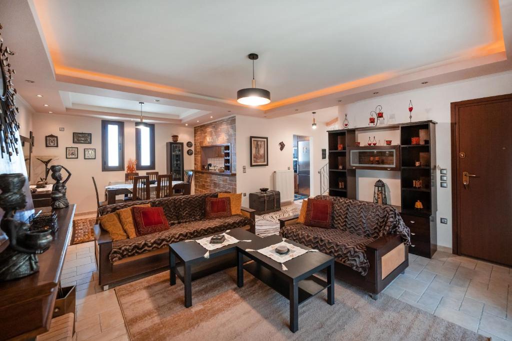 a living room with couches and a table at Perfect House in Spata in Spáta