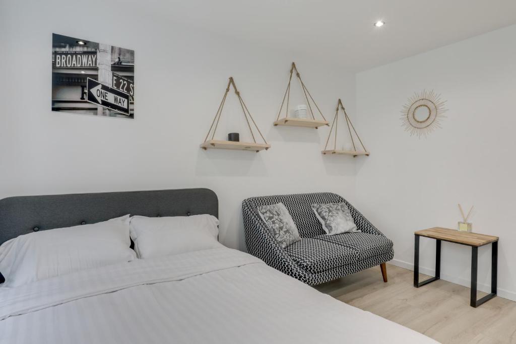 une chambre avec un lit et une chaise dans l'établissement Imhost 9 - lovely Studio Paris, Montorgueil/Marais, à Paris
