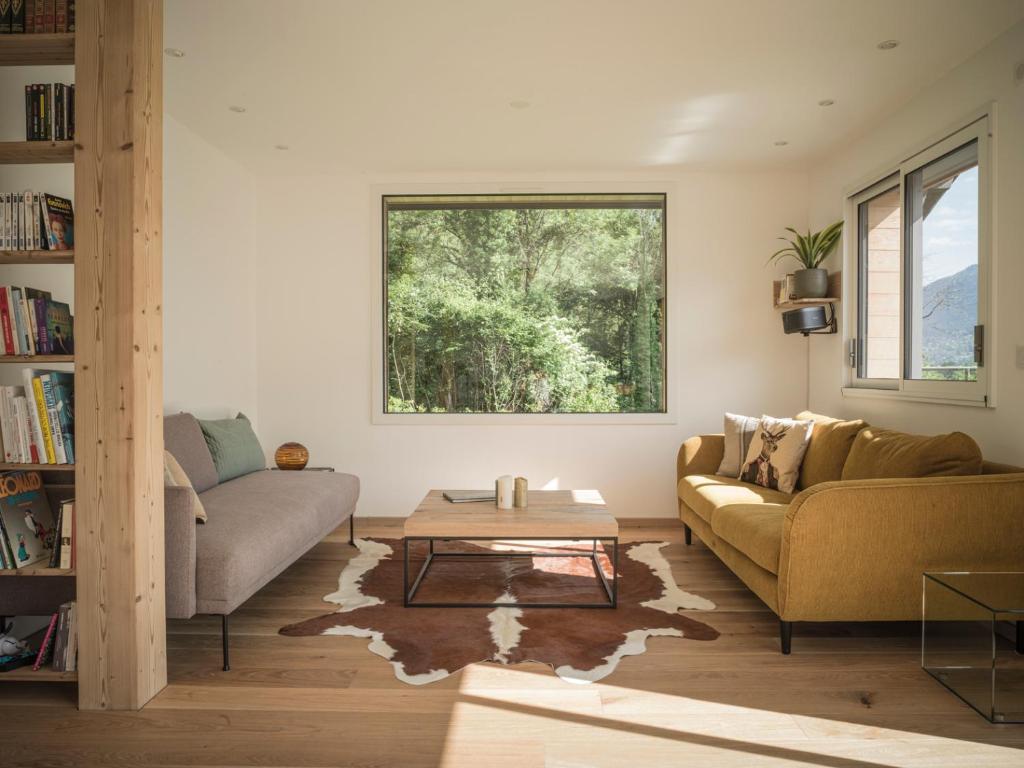 een woonkamer met een bank en een tafel bij Venez Chez Vous - Chalet de Bredanne - Bord du lac in Doussard