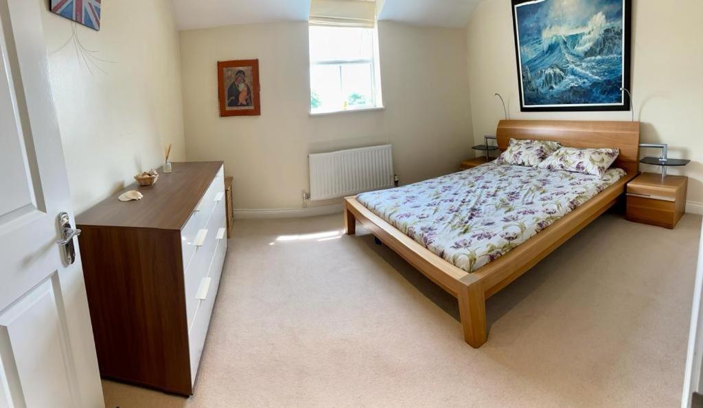 ein Schlafzimmer mit einem Bett und einer Kommode darin in der Unterkunft Mill Place in Wraysbury