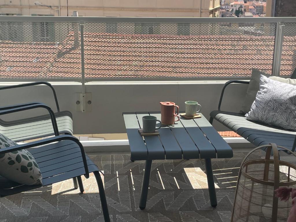 Hotel Cannes, appartement avec parking+terrasse, Croisette à pied!, a table and two chairs and a table and a couch at Cannes, appartement avec parking+terrasse, Croisette à pied! in Cannes