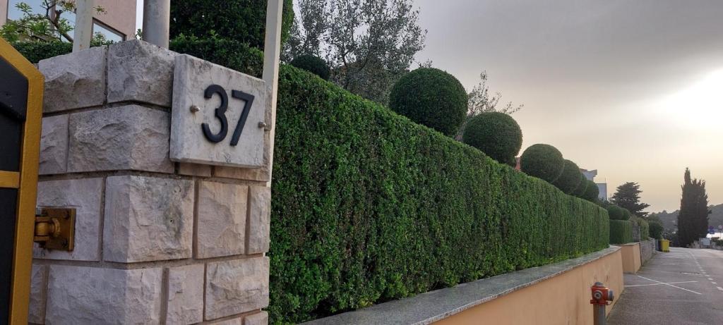 a hedge fence with the number on it at Apartments Duda in Pula