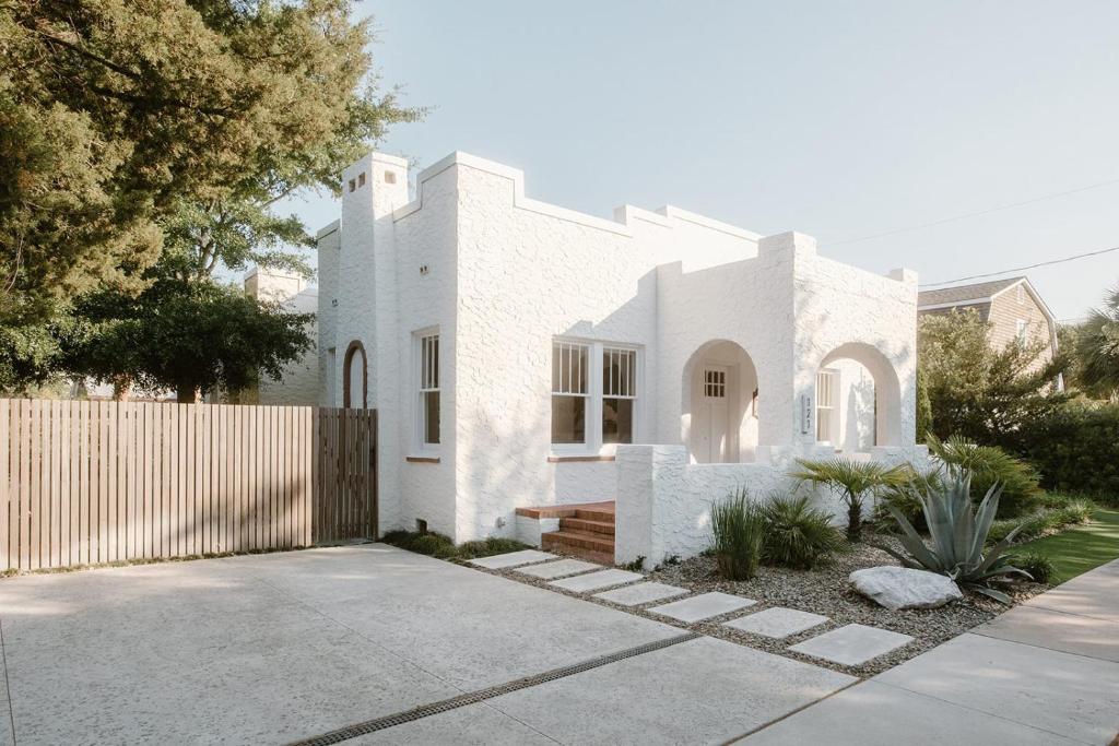 una casa blanca con valla y entrada en Villa Marguerita by WB Abodes en Wrightsville Beach