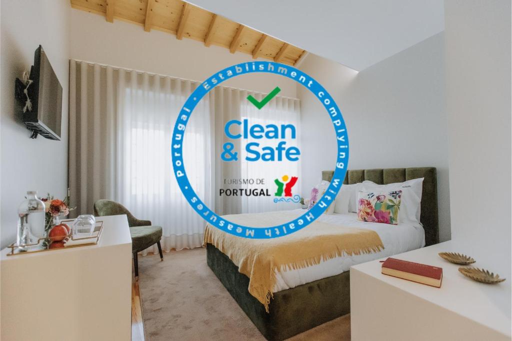 a room with a bed with a sign that reads clean and safe at Trovador Guest House in Guimarães