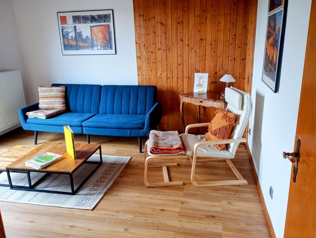 uma sala de estar com um sofá azul e cadeiras em Ferien im Brombachtal em Brombachtal