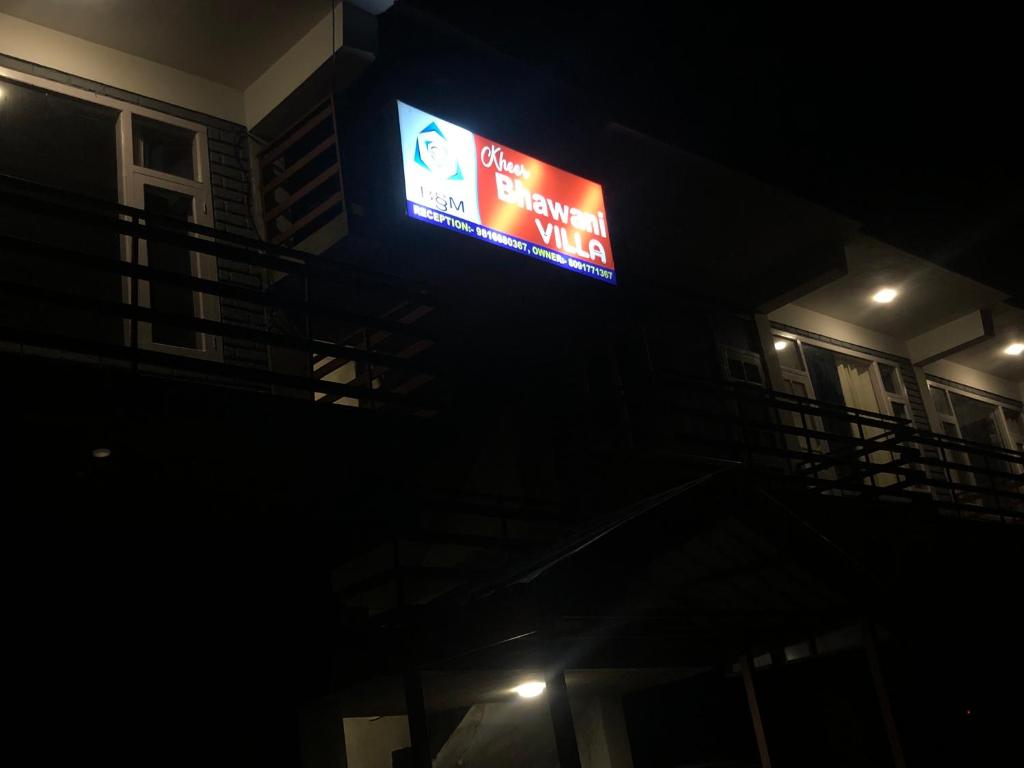 una señal en el lateral de un edificio por la noche en Kheer Bhawani Villa en Kulu