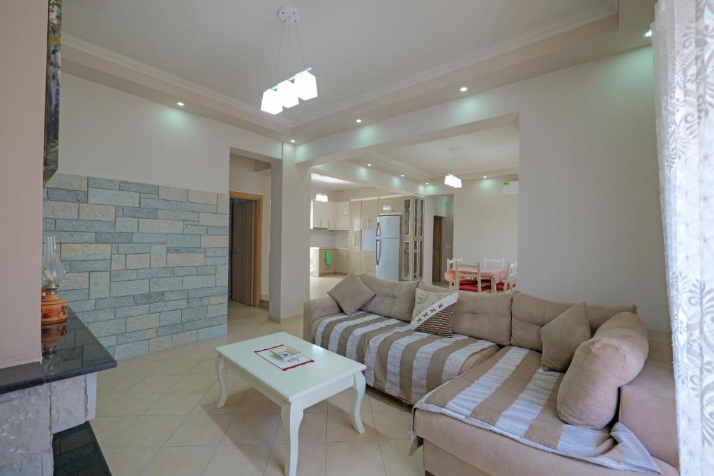 DANA HOTEL APARTMENTs في سارنده: غرفة معيشة بها أريكة وطاولة