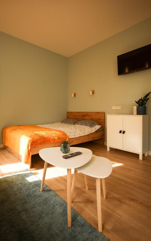 a bedroom with a bed and a table at Ozolu apartment in Liepāja