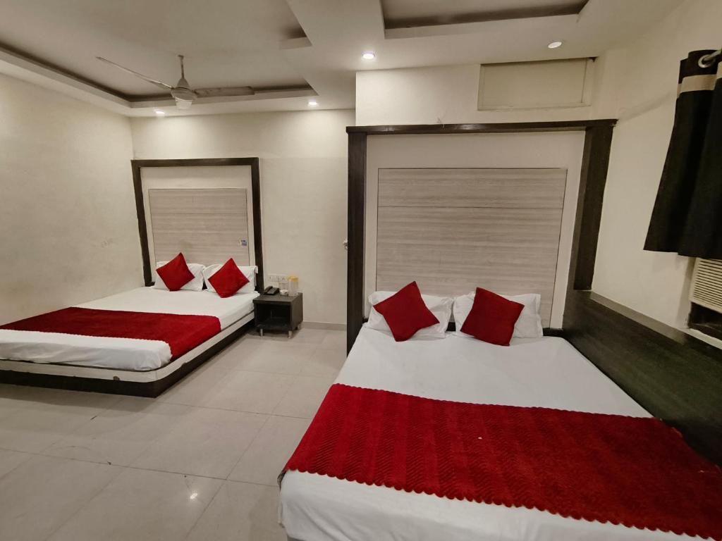 two beds in a hotel room with red pillows at Hotel Hare Krishna Paharganj Near New Delhi Railway Station in New Delhi